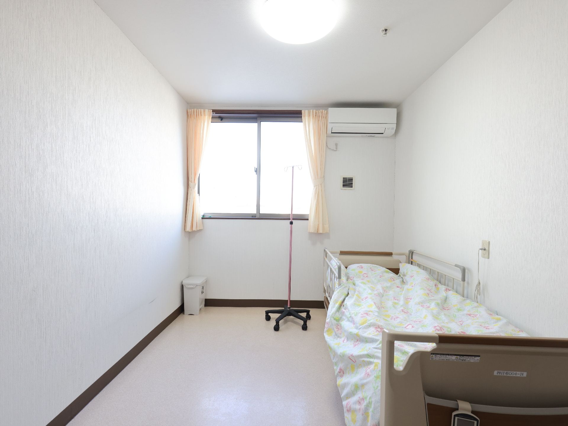 窓から日差しが降り注ぎ、介護ベッドが置かれている居室