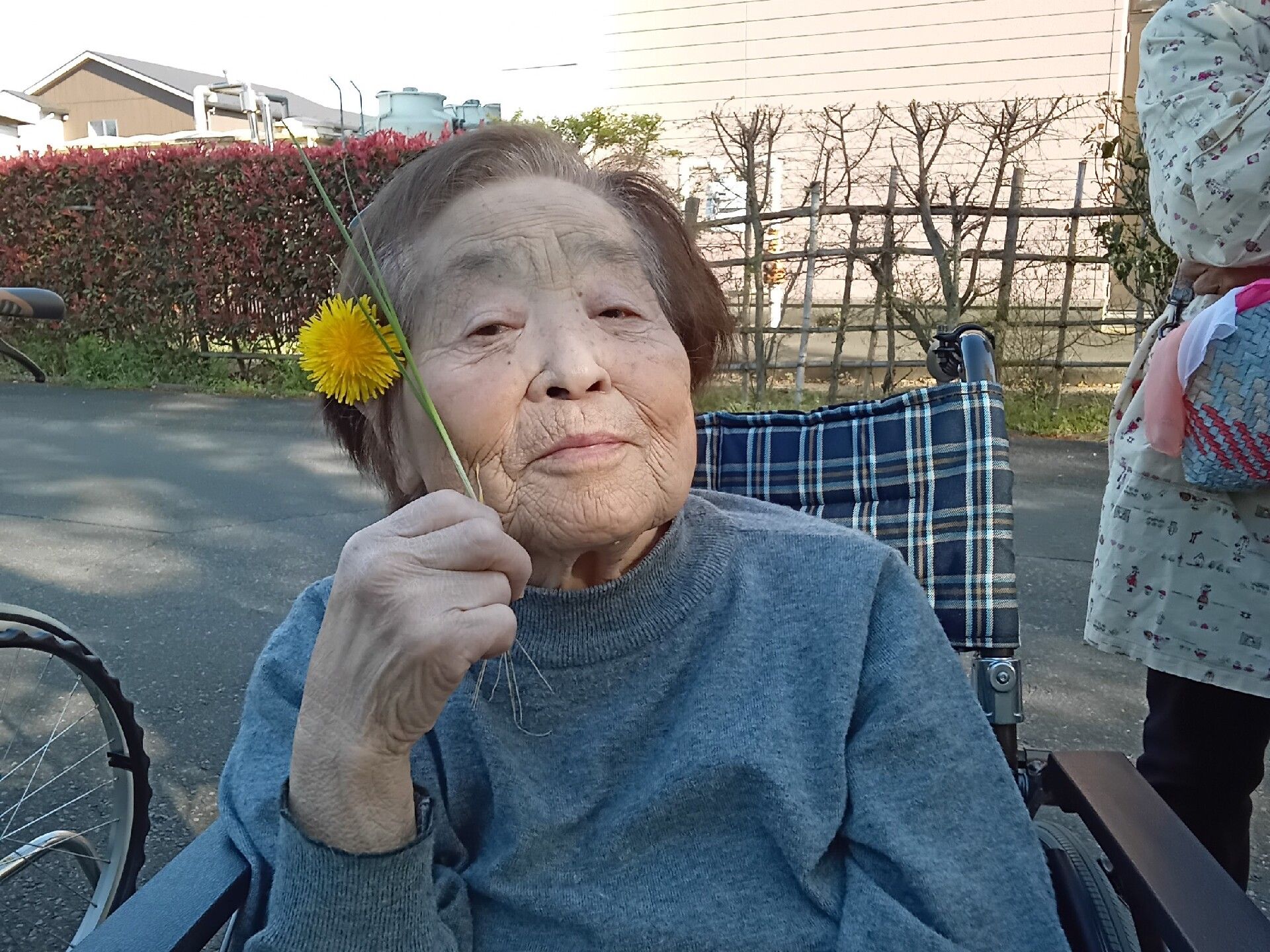 手すりがたくさん付いた一人用の浴槽が設置された浴室にはシャワーやシャワーチェアもあり、明るい。