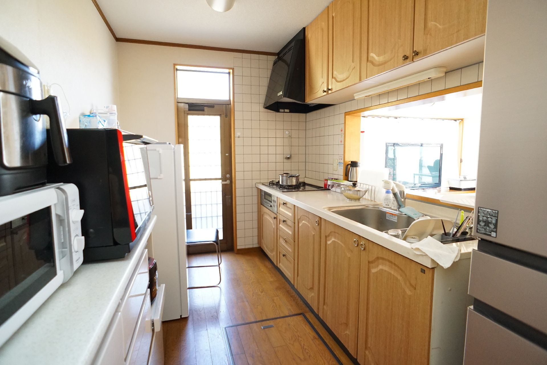 誰かに手を振っている車いすの高齢女性と付き添いのポロシャツを着た男性スタッフ。