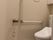 エル字型の手すりが設置され、オレンジの呼び出しボタンが付いたトイレは洋式。。