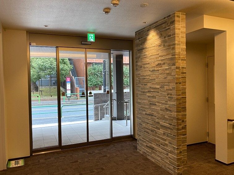 自動ドアが設置され、段差のないエントランス周辺には物が置かれておらず、外には手すりも付いている。