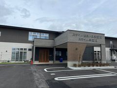 広い駐車場が付いた建物の玄関には車寄せが付き、ホーム名も書かれている。