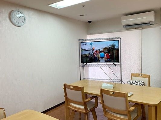 エアコン付きの食堂には木製のダイニングテーブルが複数置かれ、テレビもある。