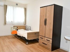 クローゼットや介護ベッド、車いす対応の洗面所が付いたフローリングの部屋にはエアコンもある。