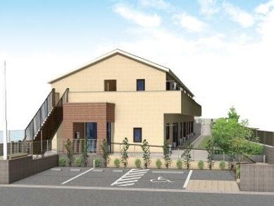 ベージュの外壁の２階建ての建物は日当たり良好で屋外階段やベランダが付き、駐車場がある。
