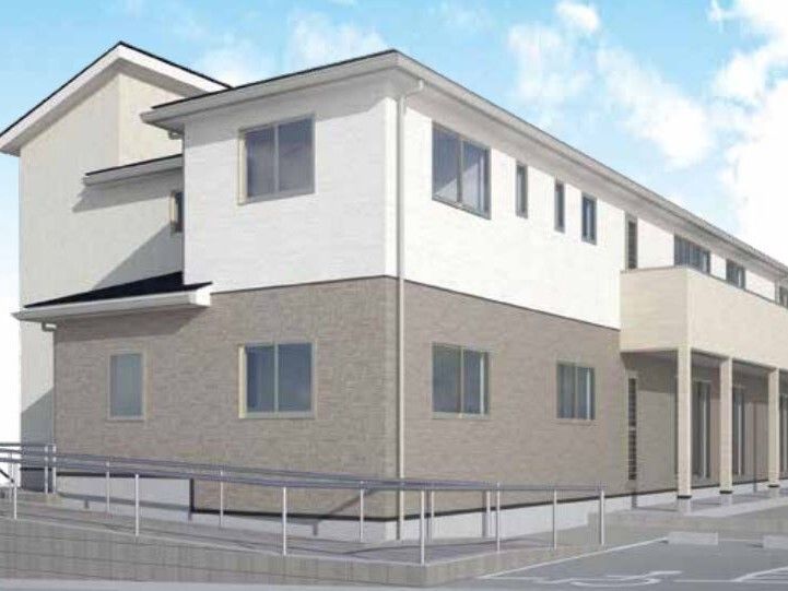 白とブラウンの２階建ての建物は日当たり良好で玄関からはスロープが付いている。