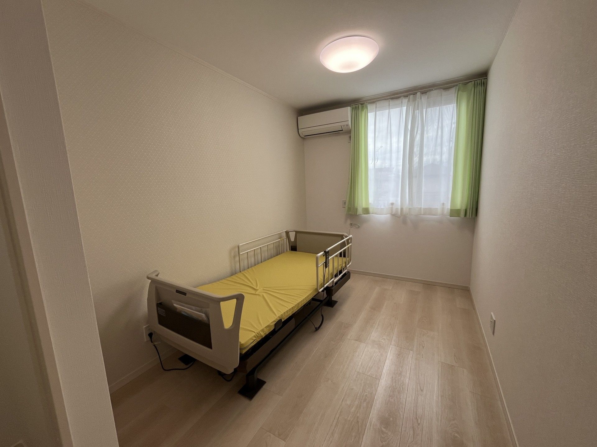 笑顔で話しているポロシャツを着た若い女性スタッフと白髪の高齢女性はテーブルを囲んでいる。