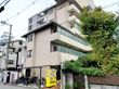車いすの高齢男性と笑顔で話している白いゆったりとした服を着た高齢女性。