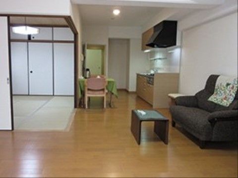 キッチンの前にテーブルセット、隣にソファーを配置した部屋