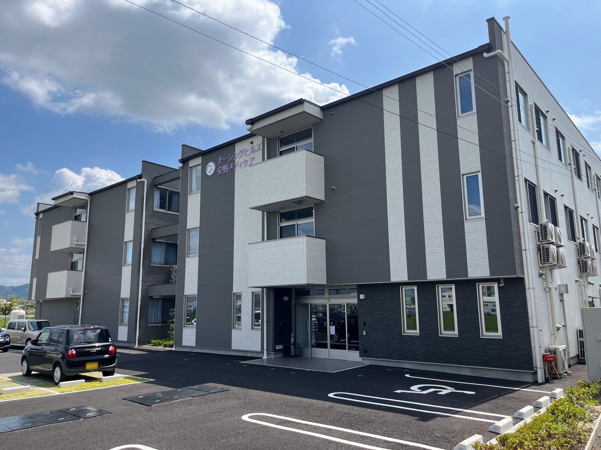 受付にて椅子に座ってパソコンを使いながら業務を行ってる女性スタッフ。