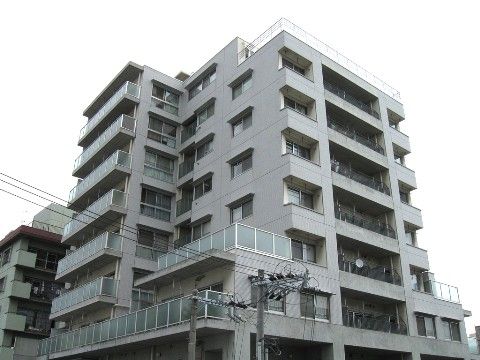 窓やベランダが複数あるグレーの背の高い建物