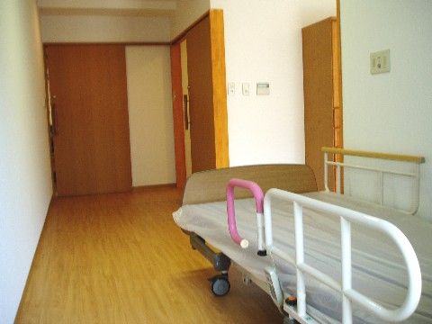手すり付きのベッドを配置したフローリングの居室