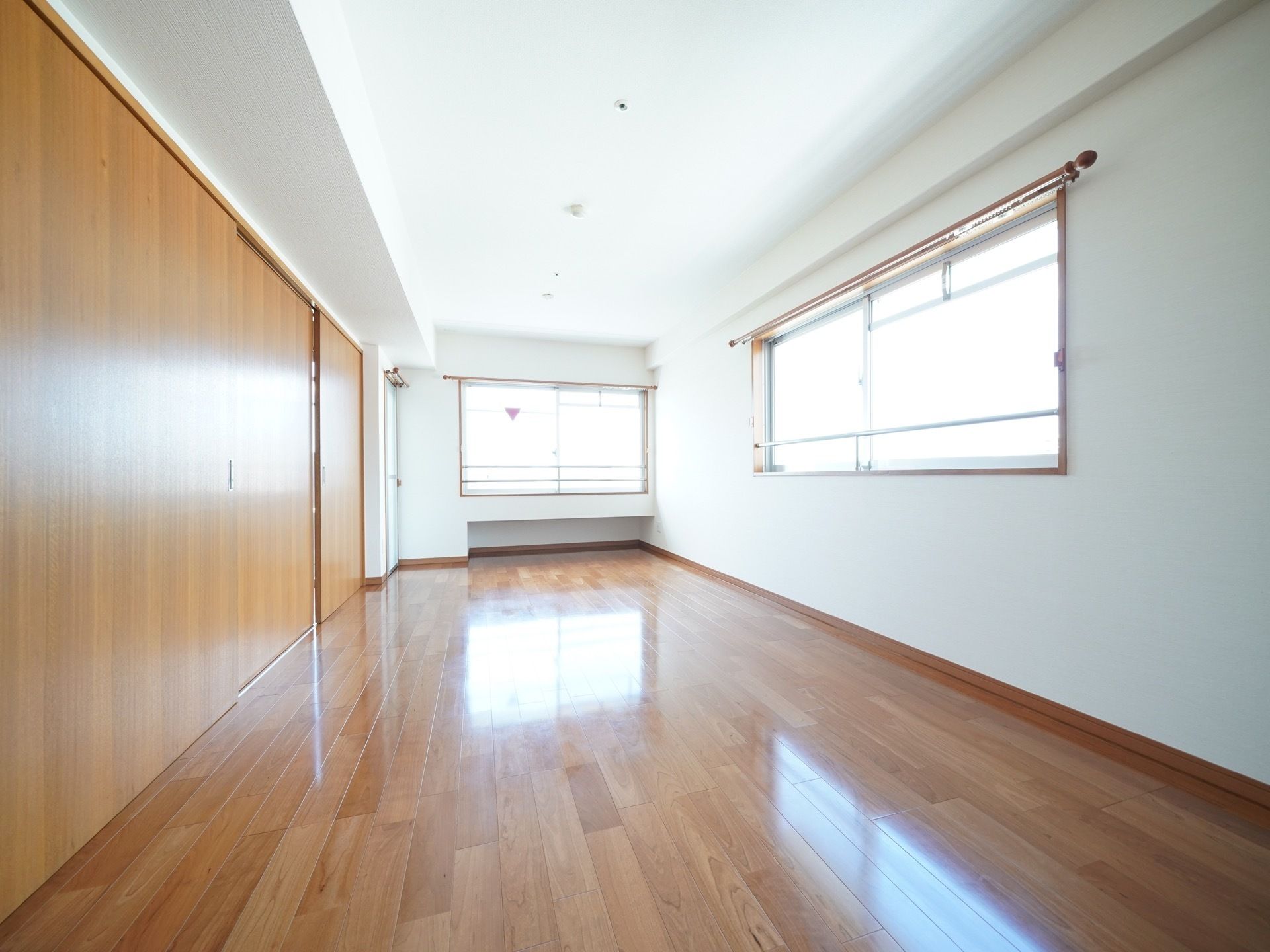 明るい居室の引違いの腰窓にはカーテンレールが設置されており、入居者様の好みのカーテンを掛けることができる。