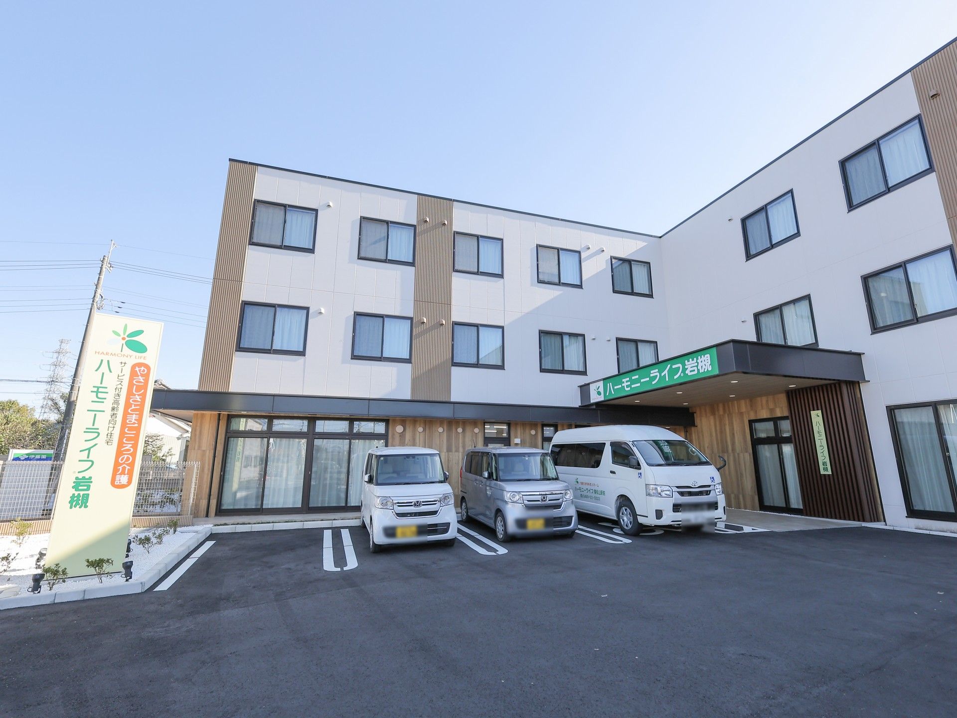 神棚の前でお祈りをしている神主とスーツ姿の男性。数名の人がいすに座ってみている。