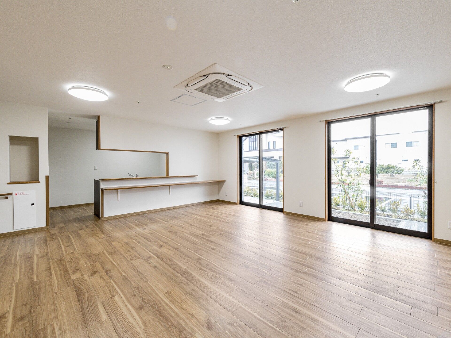 大きな窓が付いたリビングダイニングには家具や家電は置かれていない。対面式キッチンがある。