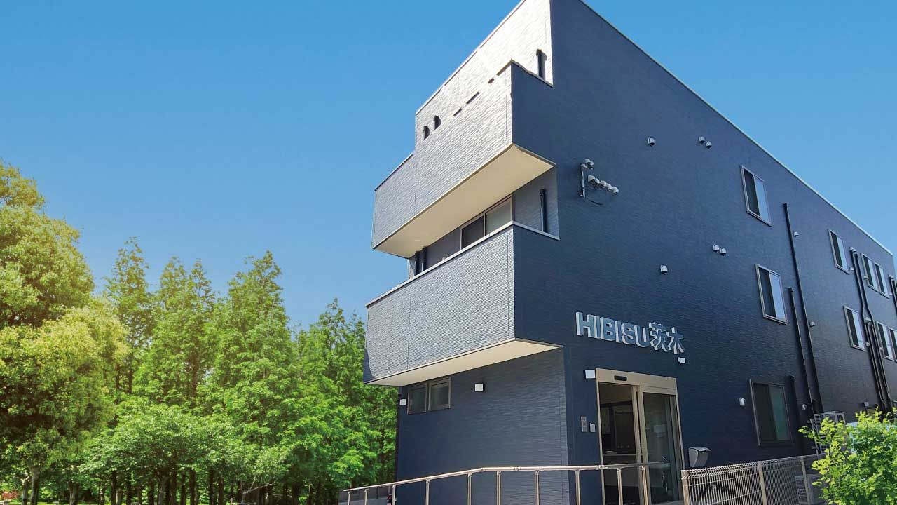 黒をメインとした3階建ての建物の各フロアにベランダがあり、屋外階段も設置されている。