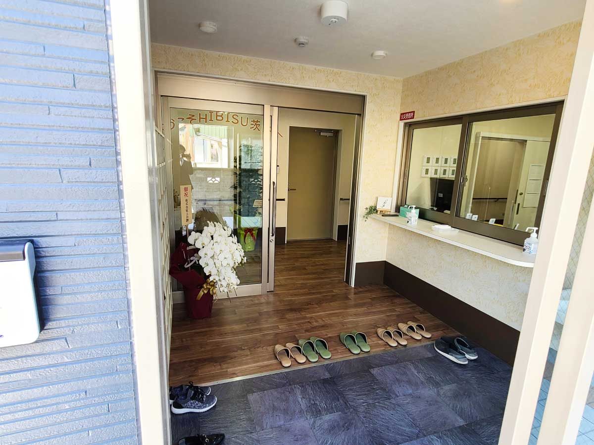 白を基調とした大きな建物は駅で、屋根付きの階段もあり、手前にはバス停がある。