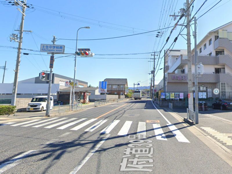 信号機や横断歩道が設置され、周りに建物が複数建っている交差点。