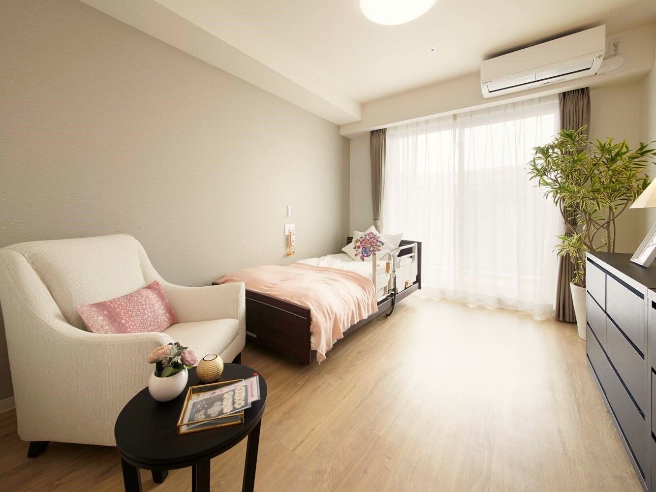 エアコン付きの部屋には寝具付きベッドやソファ、タンスなどが置かれ、ベッドサイドには緊急通報装置がある。