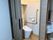 スライド式のドアが設置されたトイレにはエル字型の手すりが付き、外には洗面所もある。