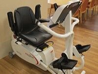 白と黒のリハビリマシン。座って手足をしっかりと動かすことができる。