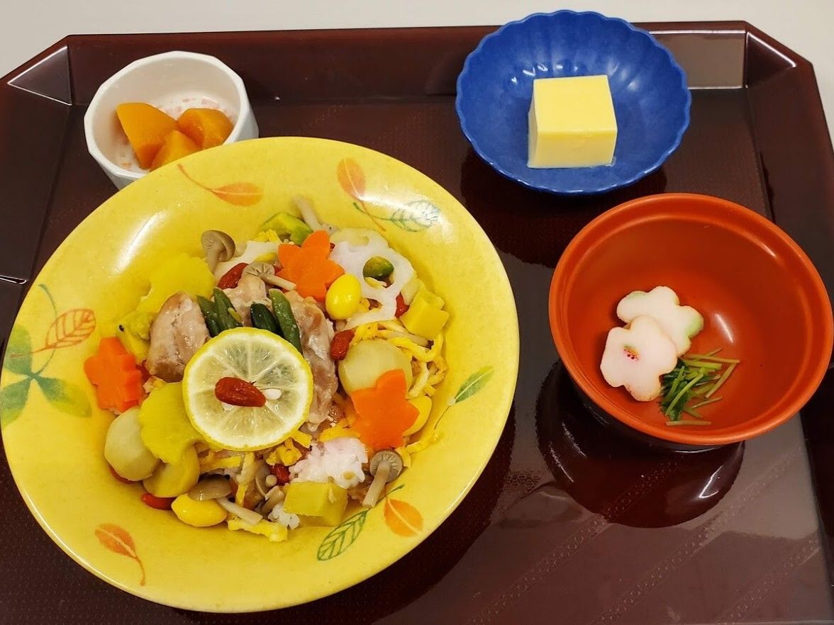 レモンの輪切りとクコの実が乗っているちらし寿司は具沢山で、吸い物や卵豆腐、柿などが添えられている。