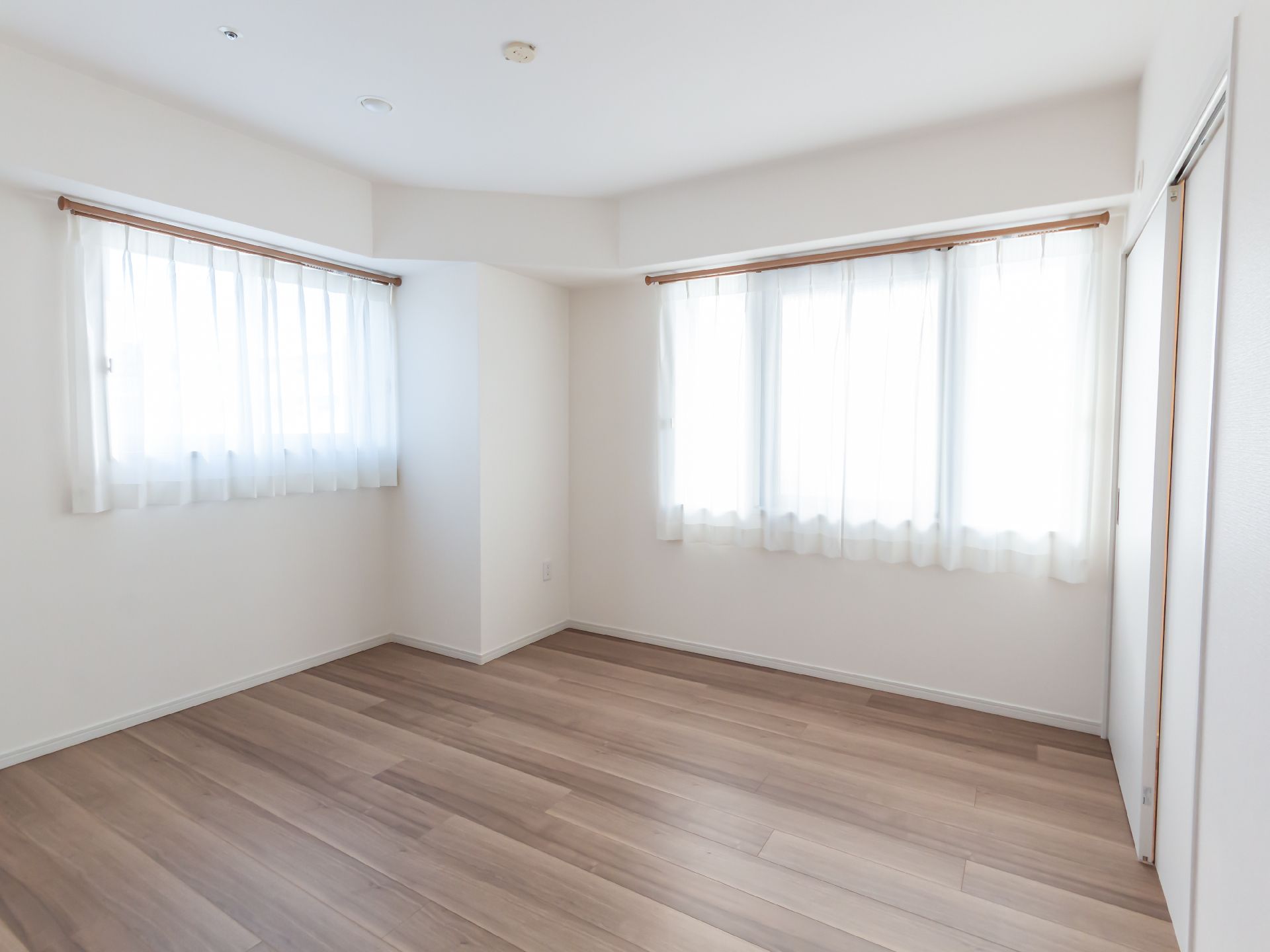 大きな窓から自然光の入る手前にキッチンが設置された部屋