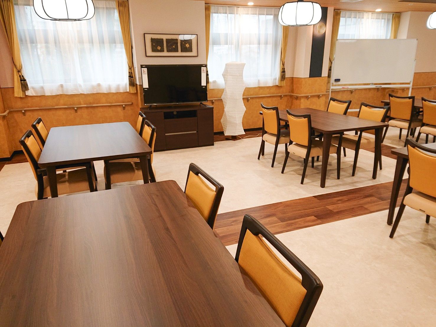 ぼんぼり風の照明があり、和風の椅子や机が設置されている広い空間
