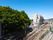 鉄道が走っていて、電車も見える。左側には林が茂り、右奥には山が連なっている。