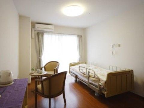 テーブルセットとベッドが配置されたエアコン付きの居室
