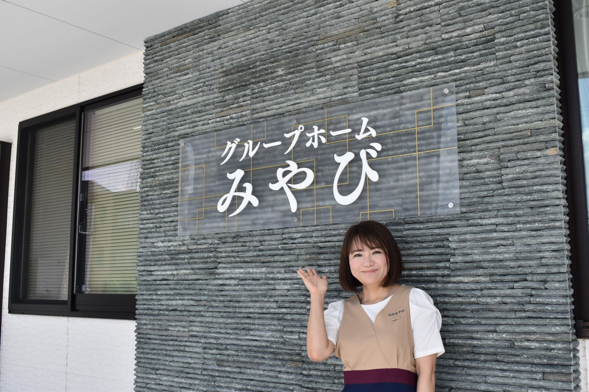 広い駐車場がある白い平屋建ての建物は日当たりのいい場所に建っている。
