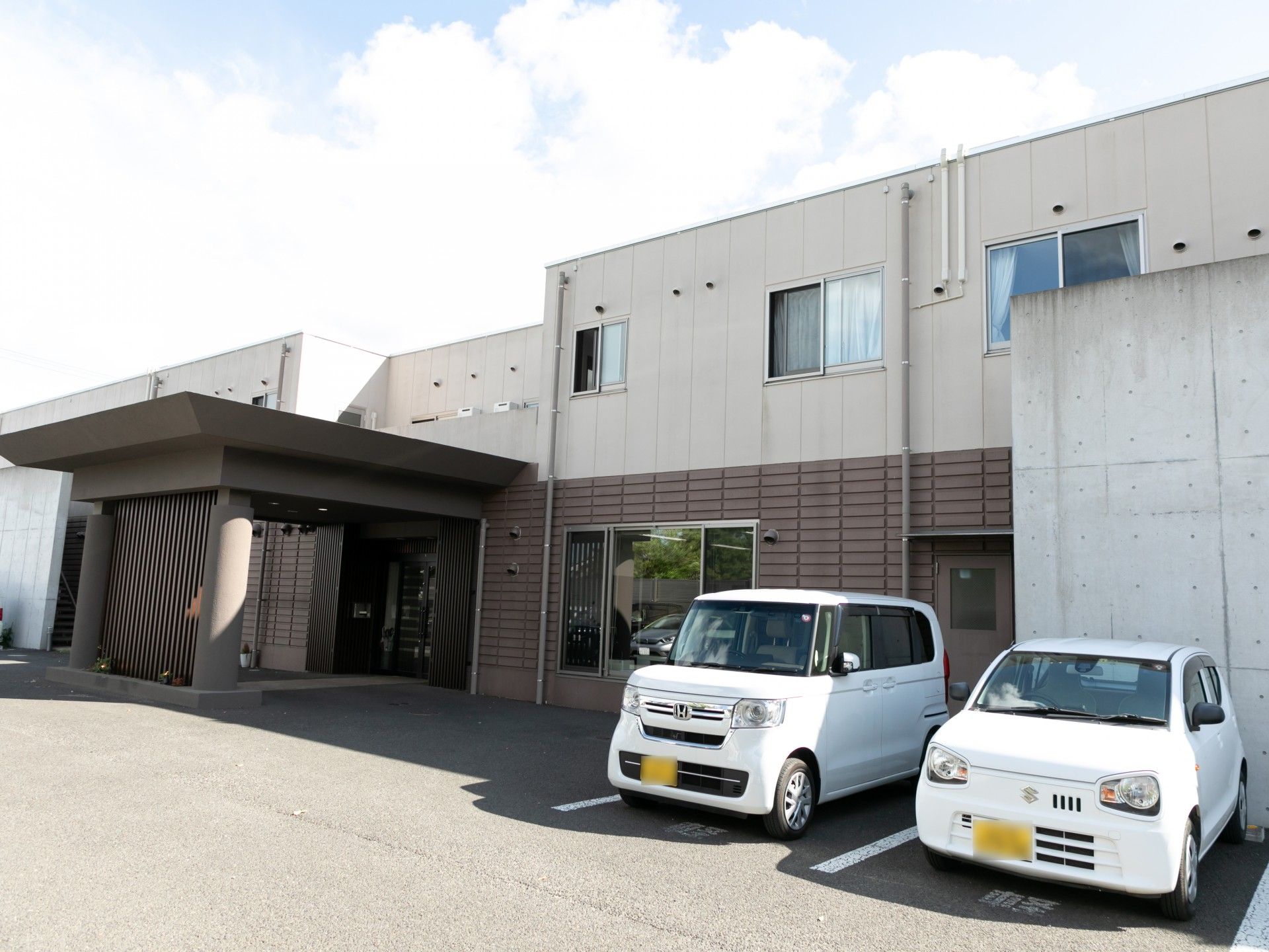 多くのソファーに囲まれた丸テーブルとエレベータがある広い空間