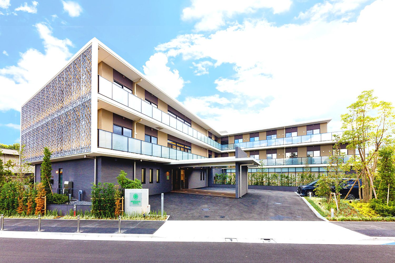 小さな木が植えられている花壇と3階建ての建物