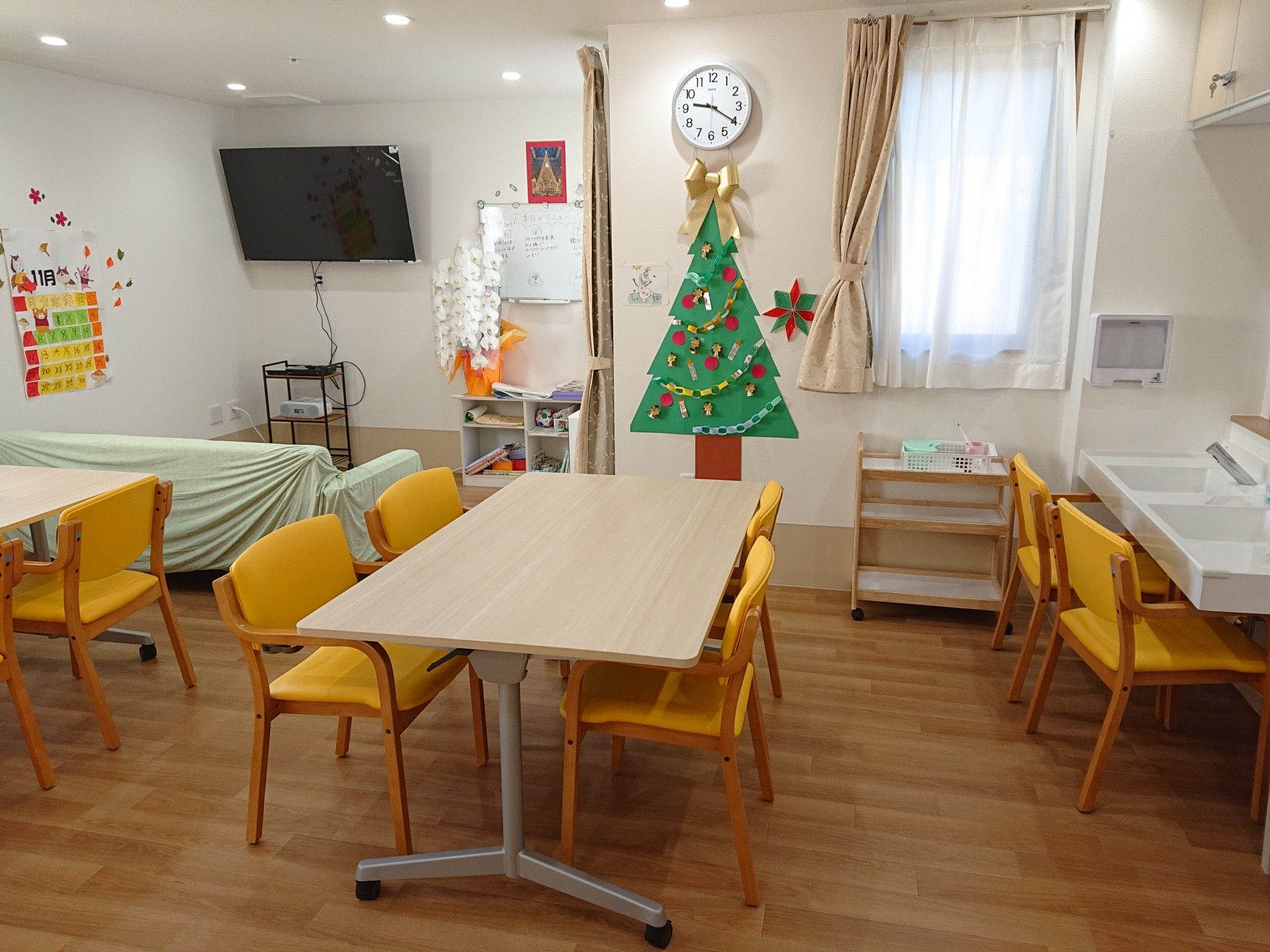 晴れた天気のもと、ご高齢な男女4名が食事をしながら親しげに会話をしている。