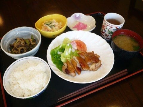 メインのお肉料理に、ごはん、味噌汁、サラダ、野菜の和え物、漬物、お茶といった栄養バランスのとれた食事である。