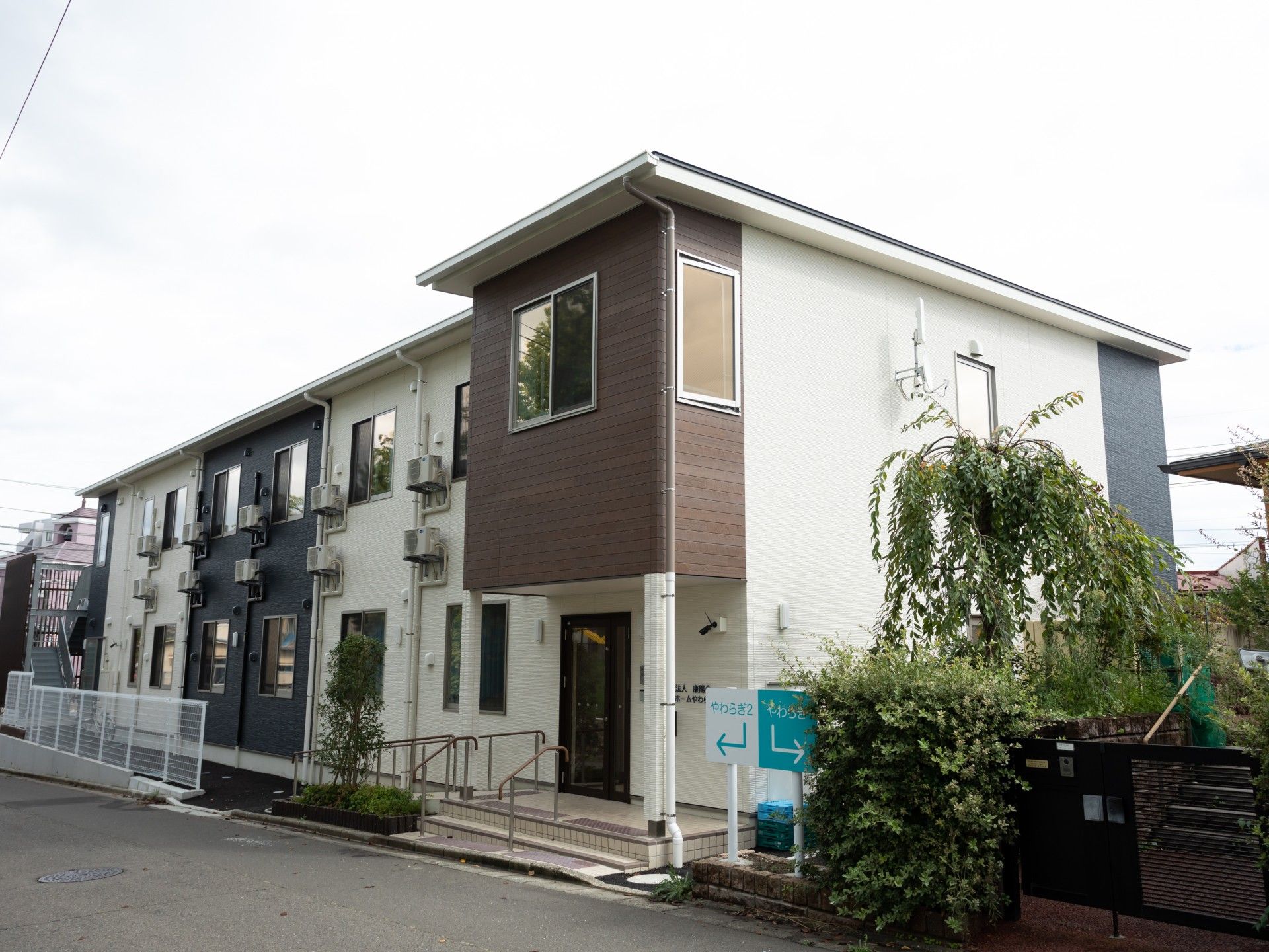 2階建ての白と紺色と茶色の建物
