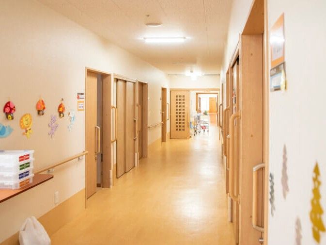 壁にさまざまな装飾があり手すりが設置されている、広々とした長い廊下