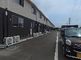 広々とした駐車場と建物の外観