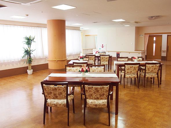 広いスペースに４人掛けのテーブルと椅子が間隔を空けて配置されている。テーブルは大きめで、車椅子をご利用の方が着席してもゆったり使える。