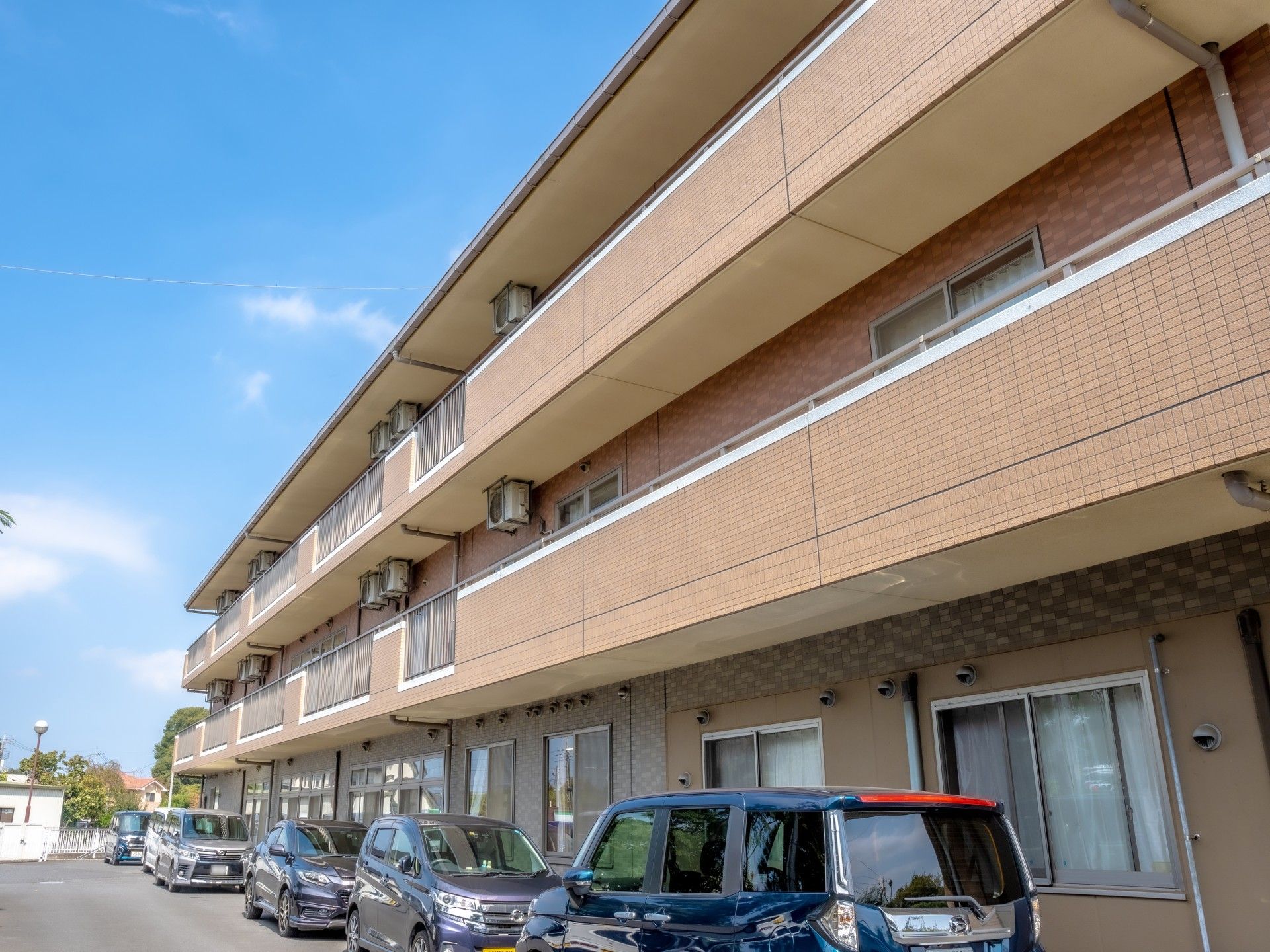 ブラウンを基調とした外壁で、落ち着いた印象の3階建て施設