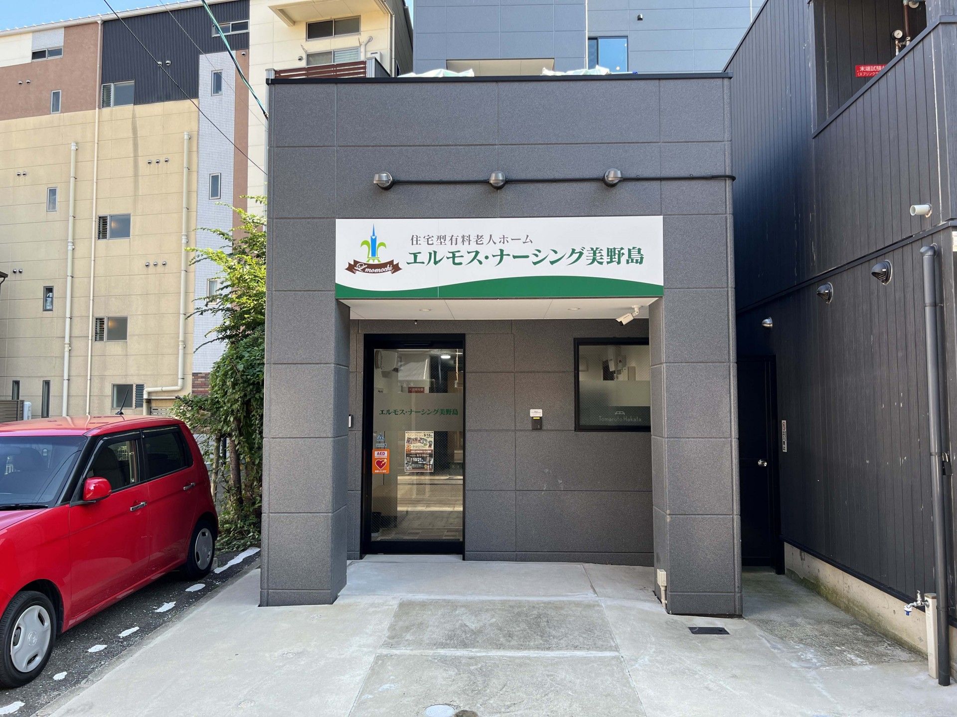 赤い車が隣に泊まっている建物