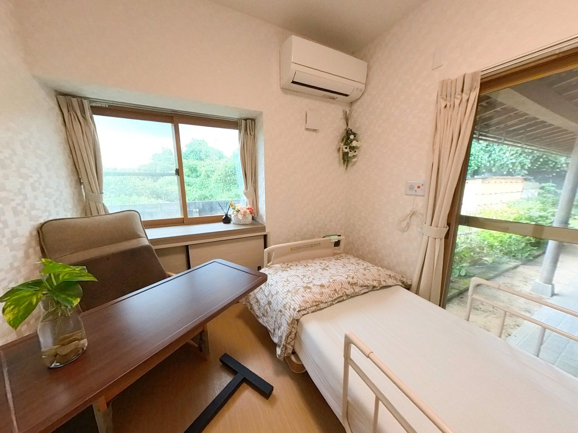 窓際のベッドと机の部屋