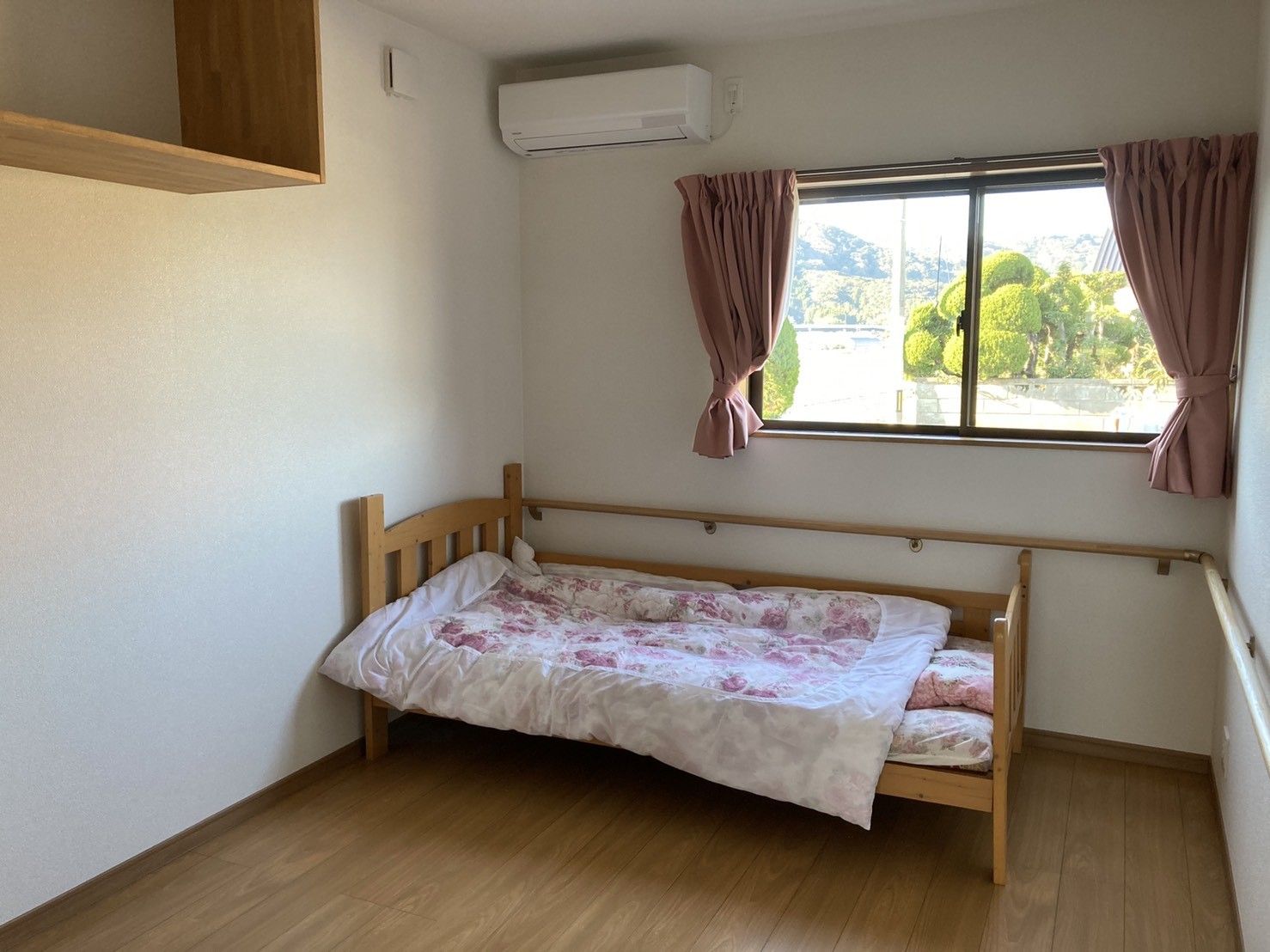 お部屋にはベッド、エアコン、窓が設置されている。