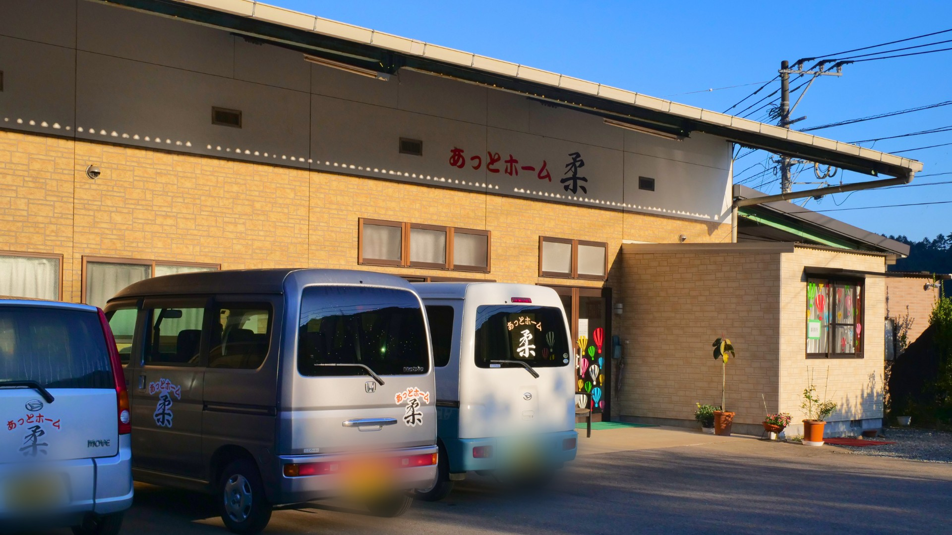 送迎車が並ぶ建物前