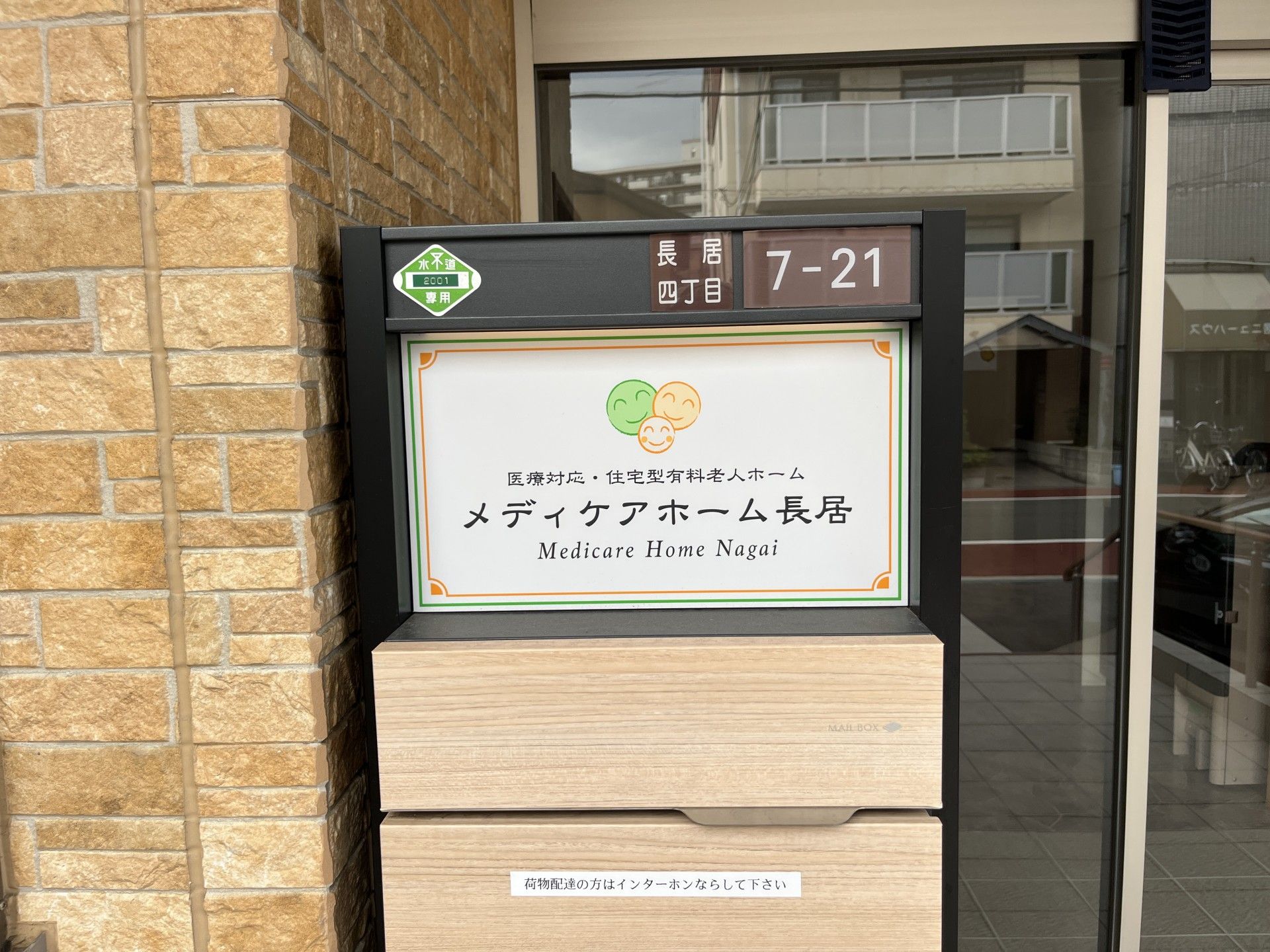 施設の表札と宅配ボックス