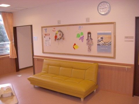 掲示板にはお知らせやカレンダーなどが掛けられており、明るい雰囲気である。ソファがあり、ゆったりとリラックスできるスペースである。