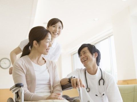 車いすの女性と2名のスタッフ