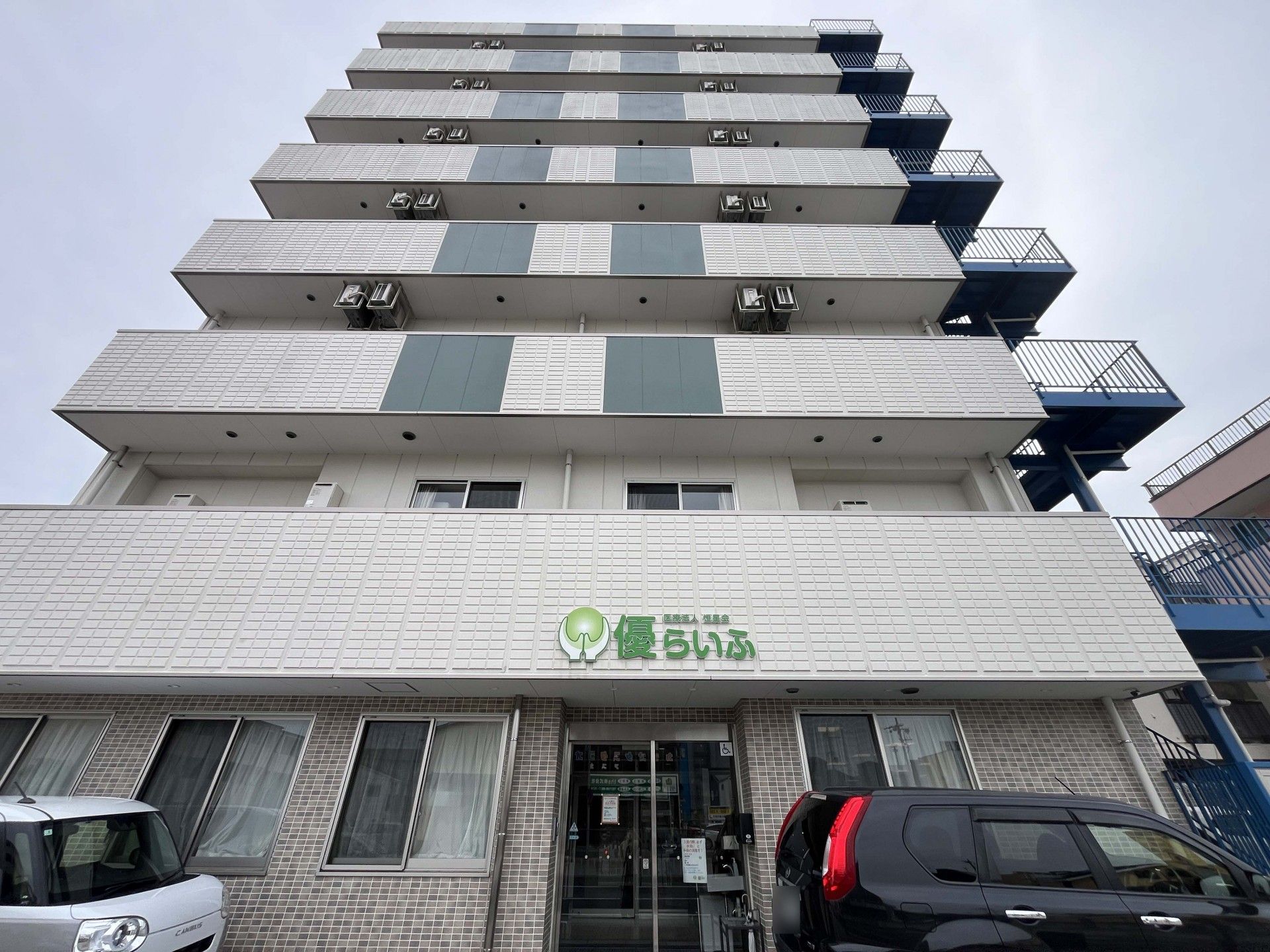 ベッドで過ごす高齢男性とお見舞いの家族