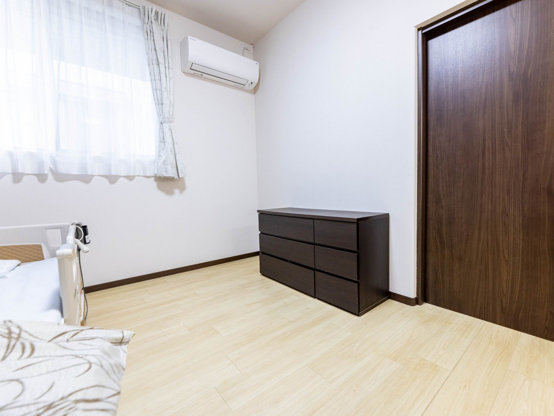 ベッドやチェストが設置された居室