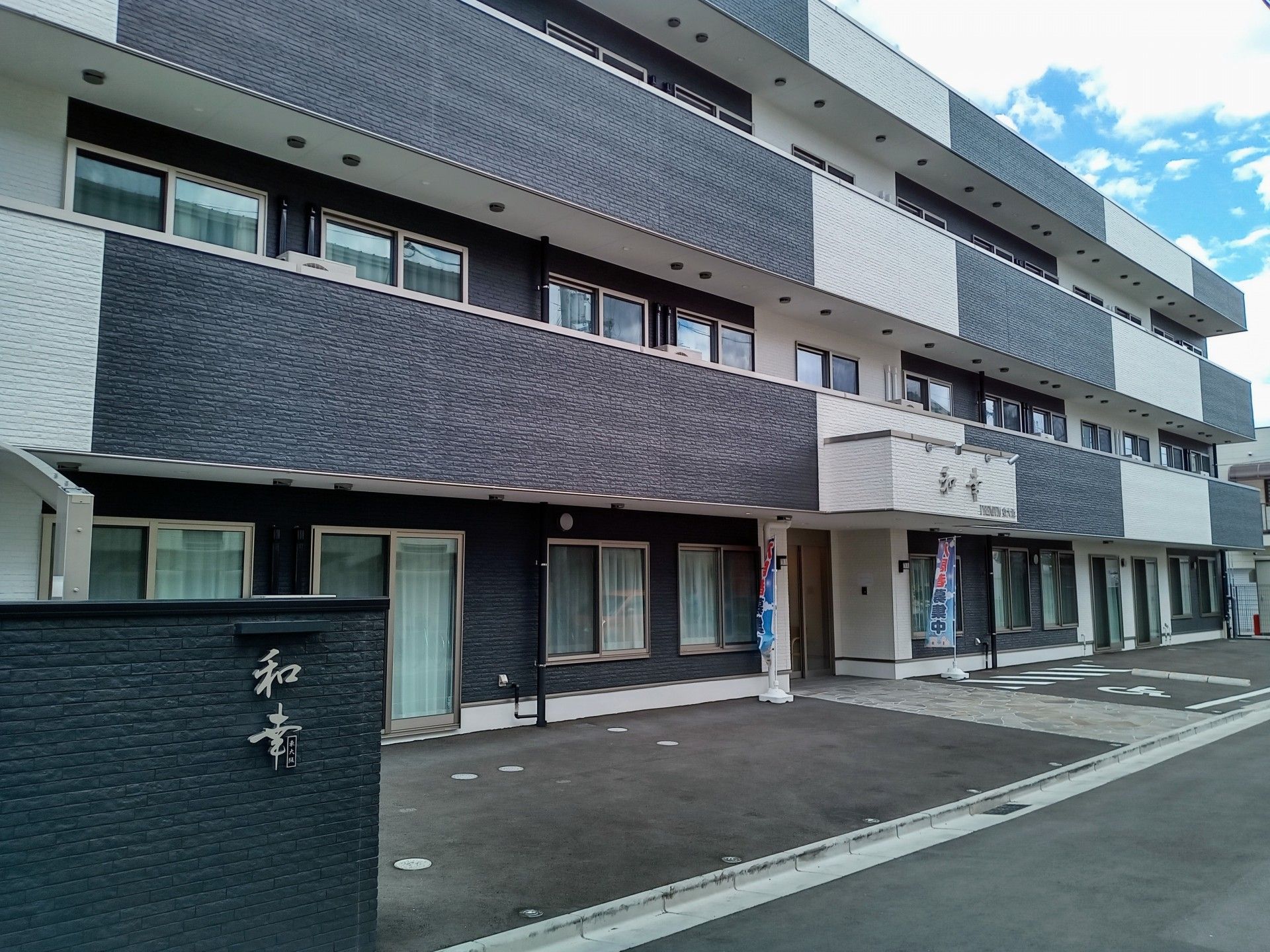 「和幸」と施設名が玄関入口に大きく書かれている。玄関前は舗装され平ら。